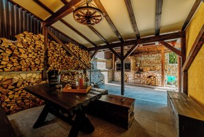 A rustic interior with a wooden table, a basket of bread, and a bottle of cold drinks.