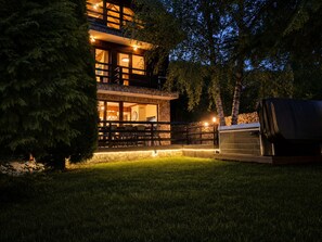 A two-story building with a balcony, outdoor seating area, and a barbecue grill.