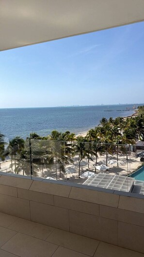 Ein Balkon mit Blick auf Strand und Meer.