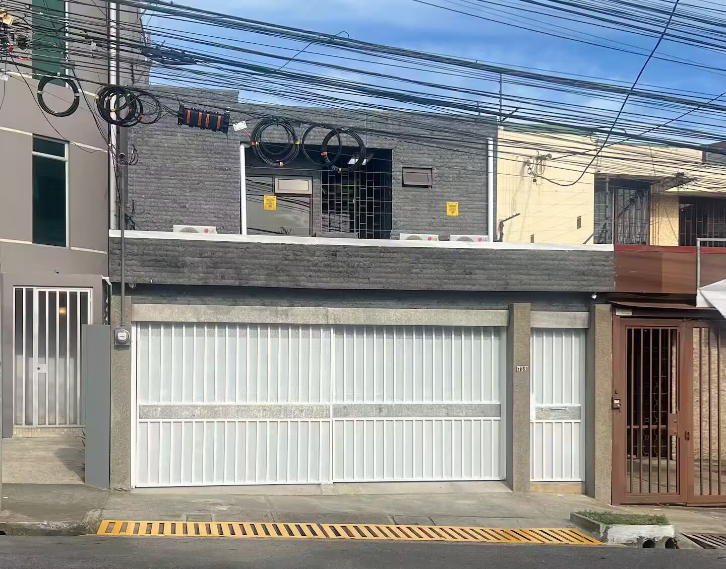 A two-story building with a garage door and a gated entrance.
