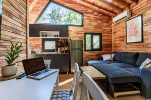 Un espacio habitable compacto con kitchenette, comedor y sofá.