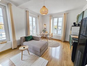 Ein modernes Wohnzimmer mit einer Couch, einem runden Tisch und einer Pendelleuchte.