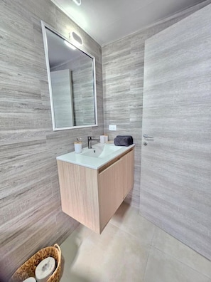 A modern bathroom with a large mirror, a sink, and a cabinet. - ANYA 5  Caribbean Apartment 1BR APT Pool view (Bayahíbe)