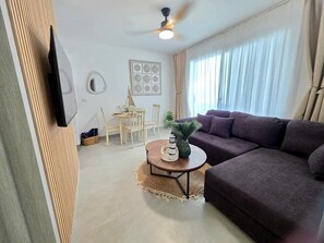 A living room with a sofa, a round coffee table, a ceiling fan, and a dining area with chairs and a table. - ANYA 5 Chic Coastal Oasis • King Bed & Balcony (Bayahíbe)