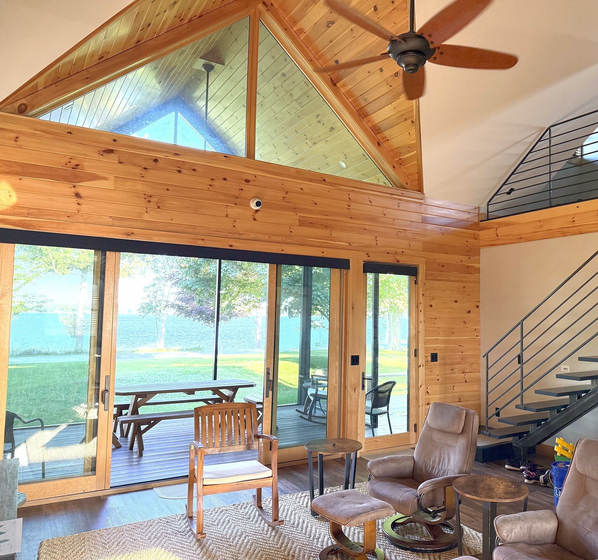 Una habitación amplia con techo alto, ventanas grandes y vista a un espacio verde.