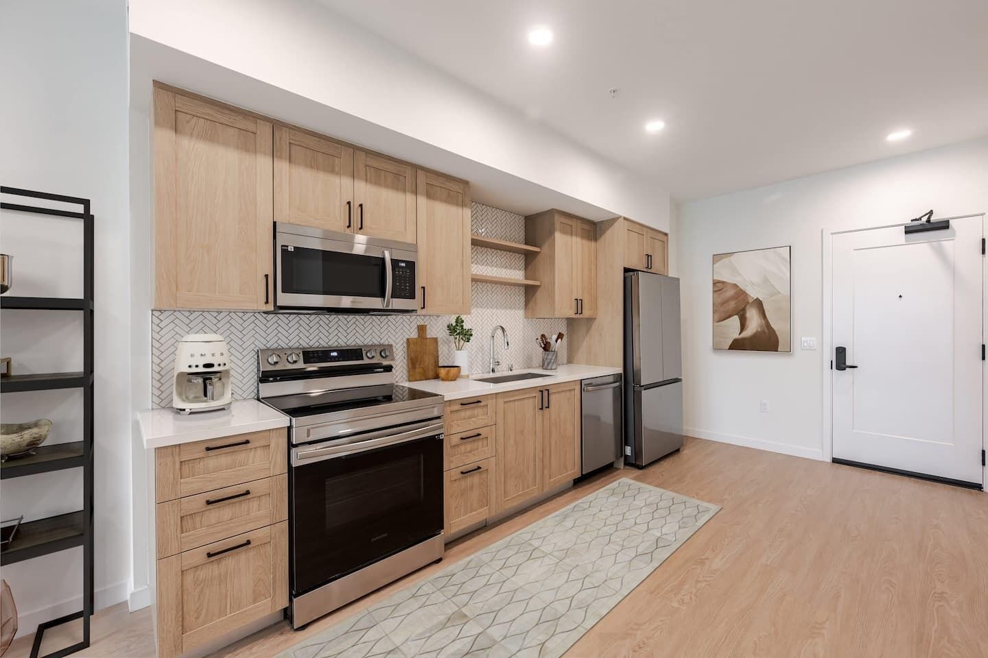 A modern kitchen with wooden cabinets, stainless steel appliances, and a herringbone tile backsplash.