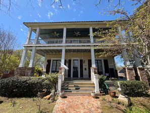 A two-story house with a front porch, a staircase leading to the entrance, and a brick pathway. - The Steamboat House, Pelican Parlor-Bed&Breakfast Style Experience Natchitoches (Natchitoches)
