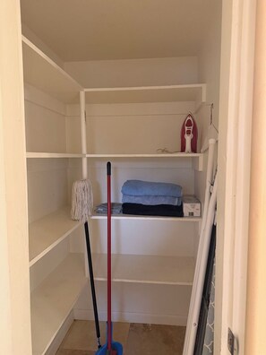 A storage closet with shelves, a mop, and an ironing board. - Cute 2-bedroom apartment with AC in vibrant Tucson,Outdoor area with Patio & BBQ (Tucson)