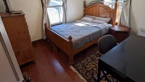 A bedroom with a bed, a desk, a ceiling fan, and a window. - Gingerbread Home | Quiet Stay | 30+ Day Ready (Chattanooga)