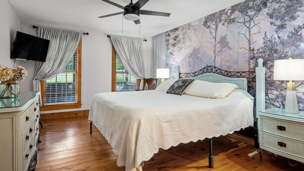 A bedroom with a bed, a ceiling fan, a TV, and a wall with a tree mural. -  NEW LISTING 3BR CABIN NEAR FALLS CREEK FALLS, LARGE SCREENED IN PATIO HOT TUB, (Spencer)