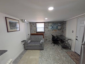 A compact living space with a sofa, a dining table, and a refrigerator. - Gingerbread Studio w/ Private Entry | 31+ Days (Chattanooga)