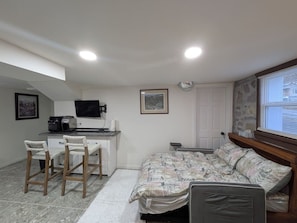A compact bedroom with a bed, a desk, and two chairs. - Gingerbread Studio w/ Private Entry | 31+ Days (Chattanooga)