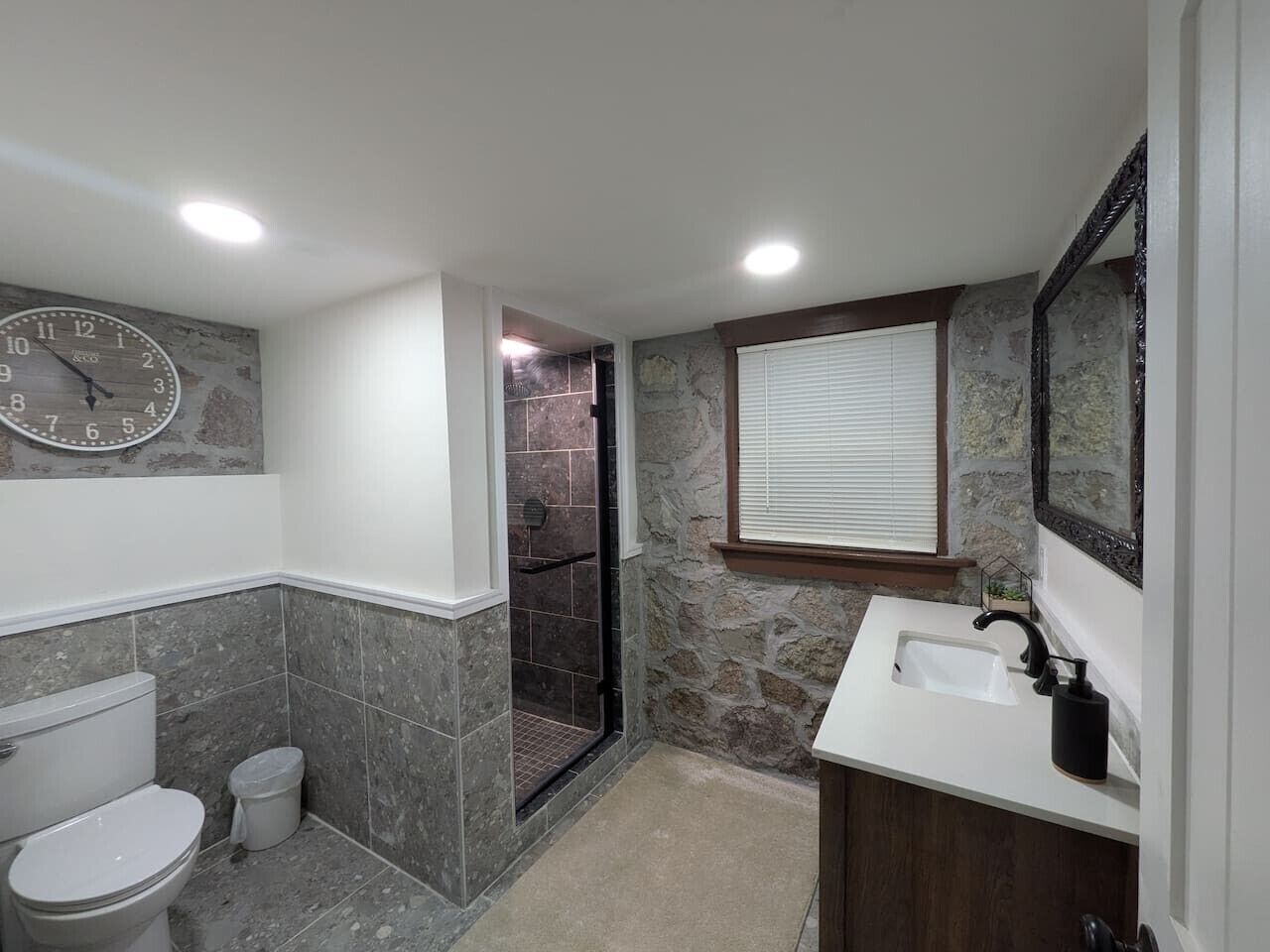 A bathroom with a toilet, shower, and sink.