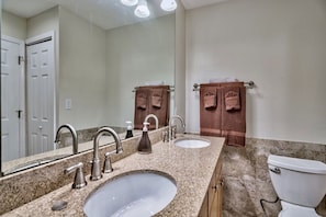 A bathroom with two sinks, a mirror, a toilet, and towels hanging on a rack. - Polynesian #108 (Panama City Beach)