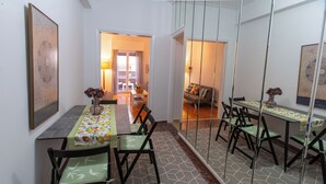 A dining area with a long table, chairs, and a patterned floor. -  Live Like a Local, Steps From Acropolis | Homey, Roomy & Sleeps 4 (Athina)