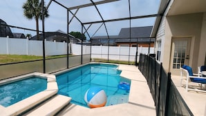 A backyard with a swimming pool, a hot tub, and a covered patio area with outdoor furniture. - Lovely home, Quiet Escape Near Disney (Kissimmee)