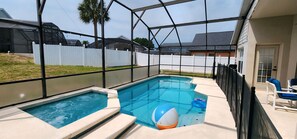 A backyard with a swimming pool, a hot tub, and a covered patio area with outdoor furniture. - Lovely home, Quiet Escape Near Disney (Kissimmee)