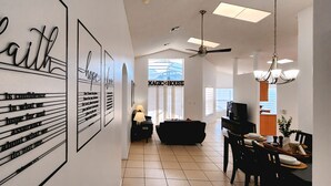 A modern interior with a dining area, a living space, and a wall with motivational quotes. - Lovely home, Quiet Escape Near Disney (Kissimmee)