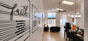 A modern interior with a dining area, a living space, and a wall with motivational quotes. - Lovely home, Quiet Escape Near Disney (Kissimmee)
