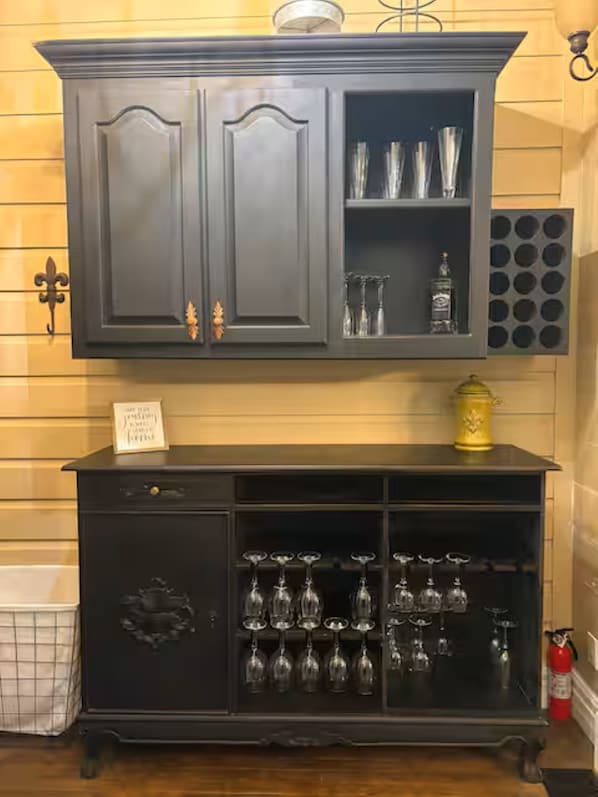 A dark wooden cabinet with glassware and a decorative item on top.