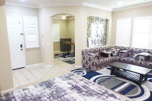 A living room with a sectional sofa, a coffee table, and patterned rugs. - Spacious 4-Bedroom House /Self Check-In/Wifi/King Bed/EV Charger/Newly Renovated (Modesto)