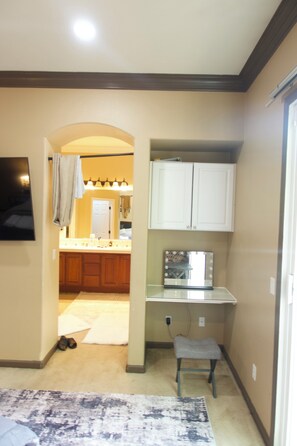 A compact kitchen with a countertop, cabinets, and a mirror. - Spacious 4-Bedroom House /Self Check-In/Wifi/King Bed/EV Charger/Newly Renovated (Modesto)