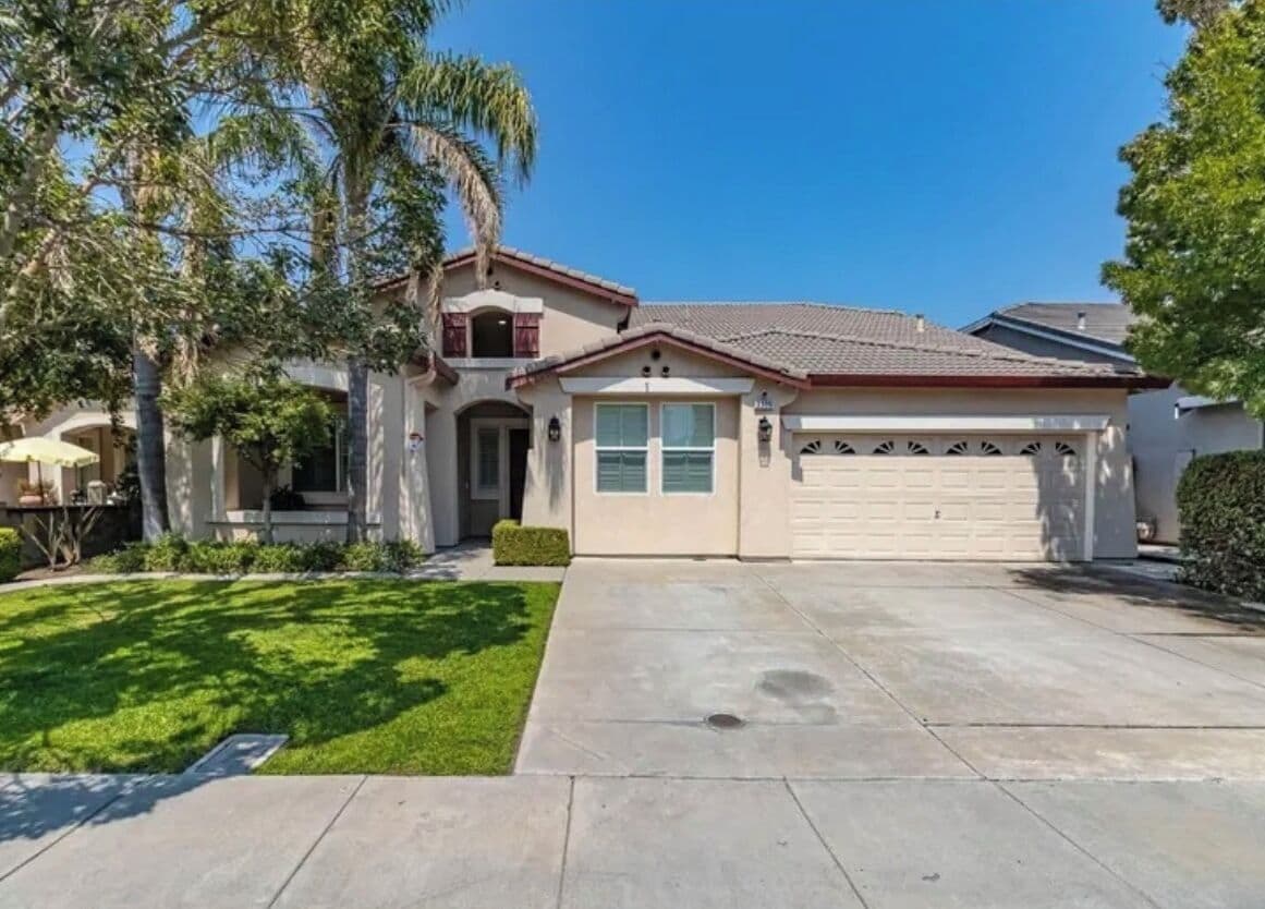 A residential house with a garage, a front lawn, and a driveway.