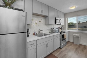 A modern kitchen with stainless steel appliances, a microwave, and a sink.
