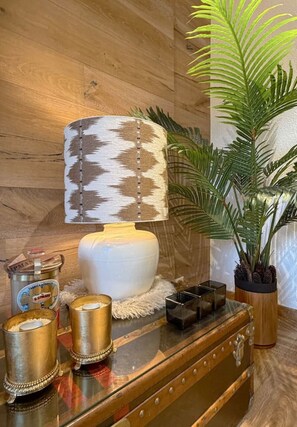 A wooden wall with a lamp, a potted plant, and a vintage suitcase with decorative items. - Beautiful apartment in a prime location in Crans-Montana (Crans-Montana)
