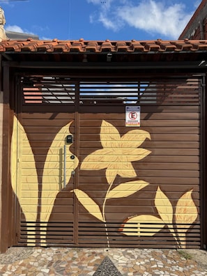 Una reja de metal marrón con un diseño floral y un letrero que prohíbe estacionar.