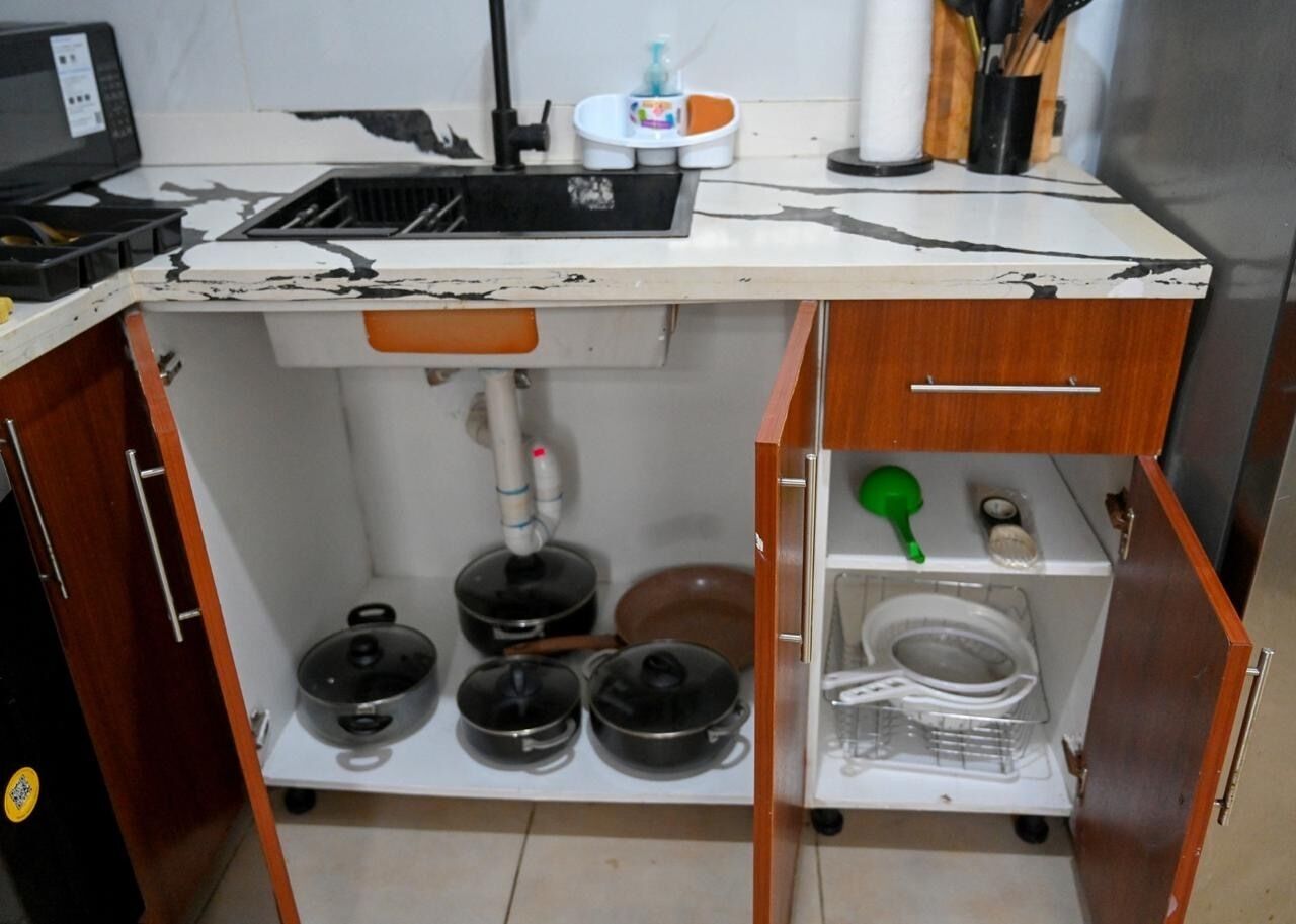 Une cuisine équipée d’un évier, d’une cuisinière et de placards.