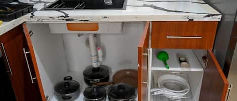 A kitchen with a sink, stove, and cabinets.