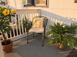 A balcony with a chair, potted plants, and a white railing. - Unit 4 - 3 Houses to Beach -  2 BR Apartment (Seaside Heights)