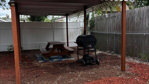 A covered outdoor area with a picnic table and a grill. - Downtown SRQ 3BR 2ba, Playground, Unit 1, Sleeps 6 (Sarasota)