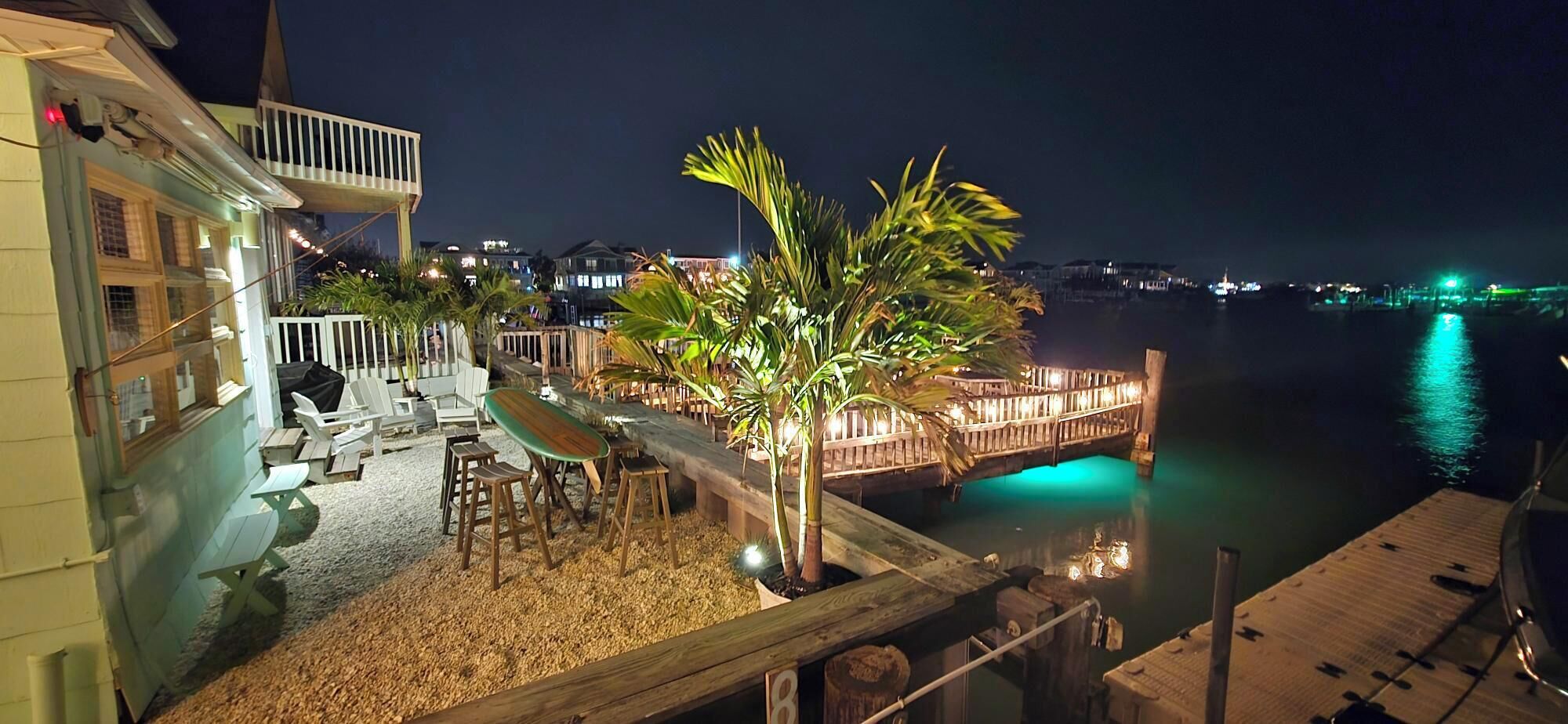 A waterfront property with outdoor seating, a wooden deck, and a view of the water.