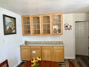 A kitchen with wooden cabinets, a granite countertop, a painting, and a 'Chef' sign. - 7-Min Down Town Reno & UNR 35 Min to MtRoseSki & Walking Distance to the Rodeo. (Reno)