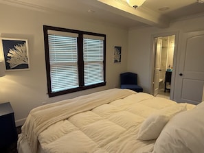 A bedroom with a bed, a chair, and a door. - 3 bedroom charming Heights cottage for relaxing under the trees (Houston)