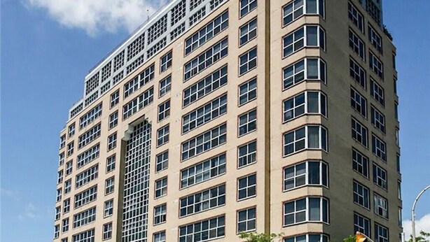 A multi-story hotel with a grid of windows, a flat roof, and a corner entrance.