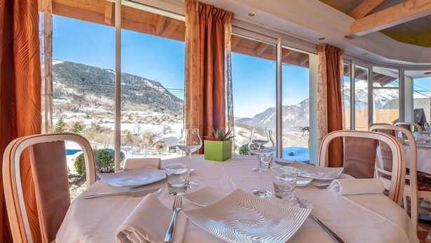 A dining table set for two with a view of a mountainous landscape. - VICC (Faverges-Seythenex)