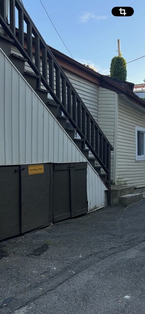 A residential building with a staircase leading to a garage. - Studio-cozy house Lowertown (Ottawa)