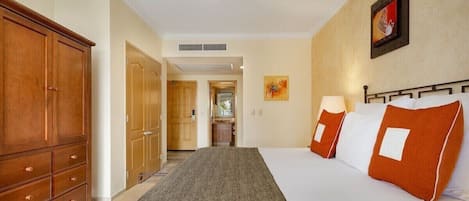 Une chambre d’hôtel avec un lit, une armoire, un ventilateur de plafond et un tableau au mur.