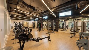 A gym with treadmills, weight machines, and a mirrored wall.