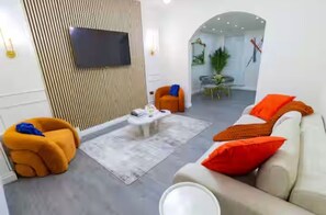 Un salon moderne avec un canapé, un fauteuil et une table basse.