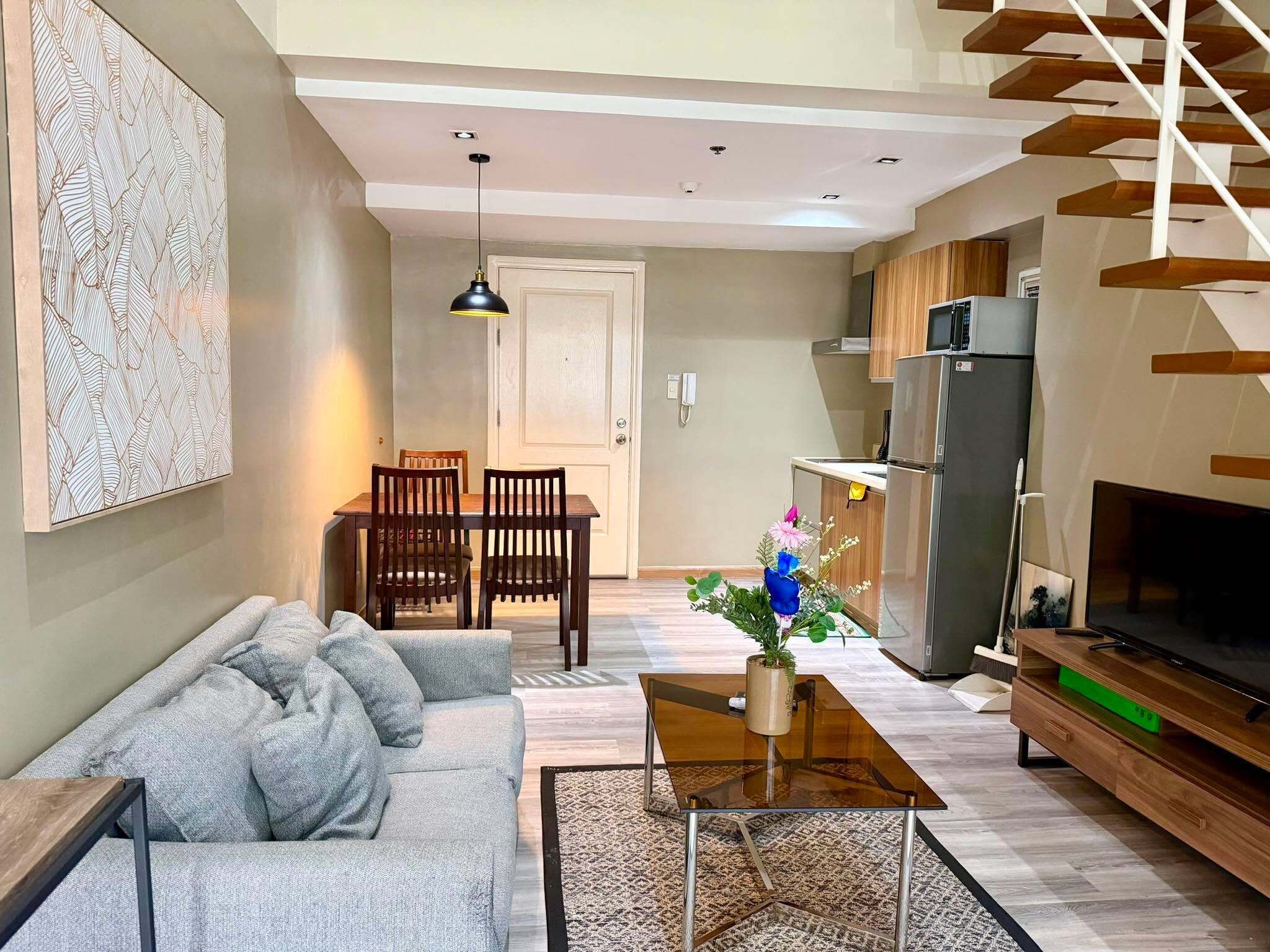 A modern living room with a sofa, coffee table, and a TV stand.