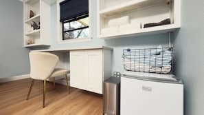 A compact room with a white desk, a chair, a window with blinds, a shelf with towels, and a trash bin. - Gorgeous Newly Renovated Getaway 2BR/ 2BA near Blue Spring State Park (Orange City)