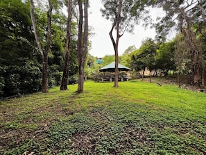 A park with a gazebo, trees, and a grassy area. - Casa Siempre Verde Ocean View (Nosara)