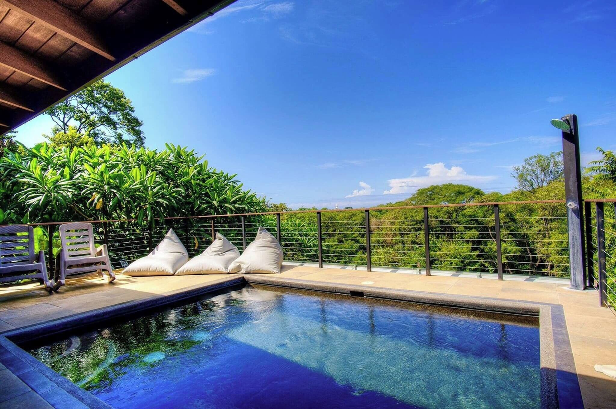 Una piscina con vistas a exuberante follaje y un cielo despejado.