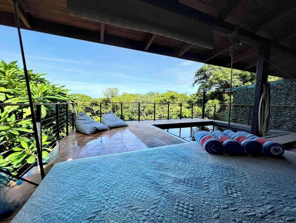 Un dormitorio con una cama grande, vistas al exterior y un balcón con barandilla.