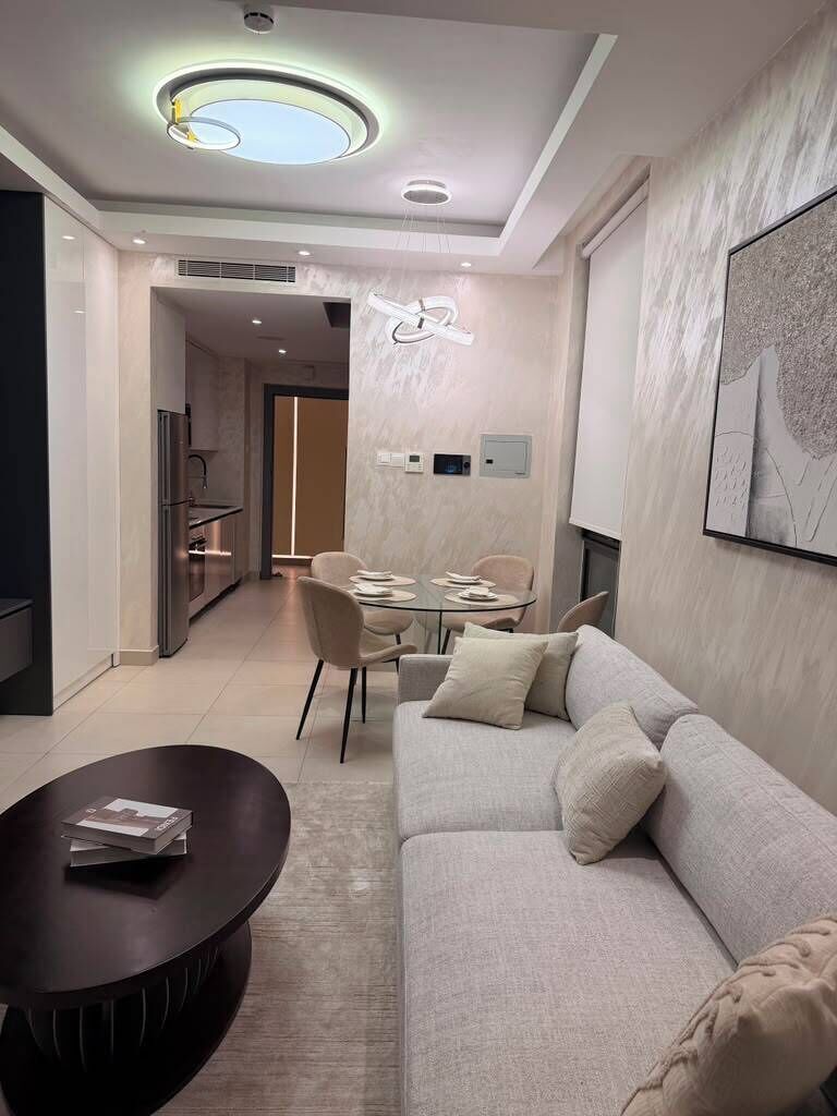 Una sala de estar moderna con un sofá, una mesa de centro y un comedor con sillas y una mesa.