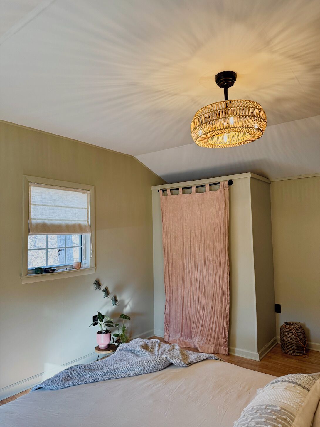 Ein Schlafzimmer mit einem großen Bett, einem Fenster mit Aussicht, einer Deckenleuchte und einem Vorhang.